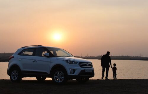 parent and child silhouette near car